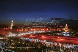 Image du Maroc Professionnelle de  Au coucher du soleil et même un peu avant la foule envahi la fameuse Place Jemaa El Fana qui se métamorphose en un gigantesque restaurant en plein air grâce aux nombreux stands et gargotes qui s'y installent sur ce lieu mythique au centre de la médina de Marrakech. Au fond le minaret de la Koutoubia, Samedi 26 Février 2005. (Photo / Abdeljalil Bounhar)

 